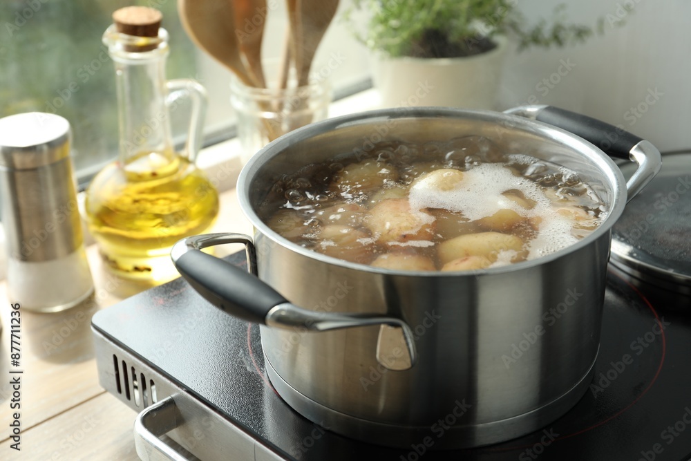 Boiling potatoes in pot on stove in kitchen Boiling potatoes in pot on stove in kitchen