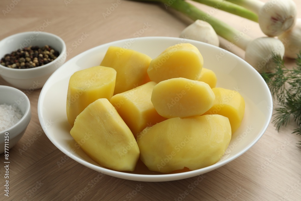 Boiled potatoes in bowl, spices, green onion and dill on wooden table Boiled potatoes in bowl, spices, green onion and dill on wooden table