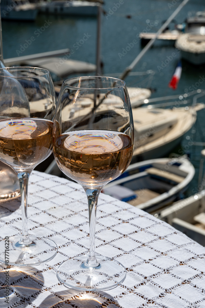 Obraz premium Glasses of cold rose gris Cote de Provence wine in yacht harbour of Port Grimaud, summer vacation on French Riviera in Provence, France