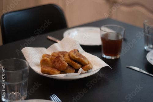 dinner table with chicken nuggets, sausages, fries and salad.