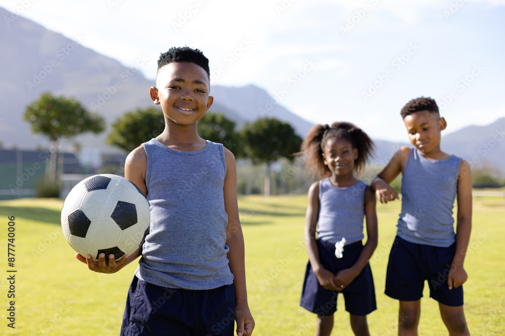 Portrait of happy african american schoolchildren playing football on field at school Portrait of happy african american schoolchildren playing football on field at school