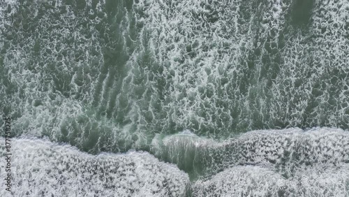 Waves slowly rolling into shore along Pacific Northwest coast. Calming ocean scene top down aerial view (HDR 4K ProRes drone footage) photo