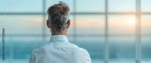 Jobless individual staring out window, pondering opportunities photo