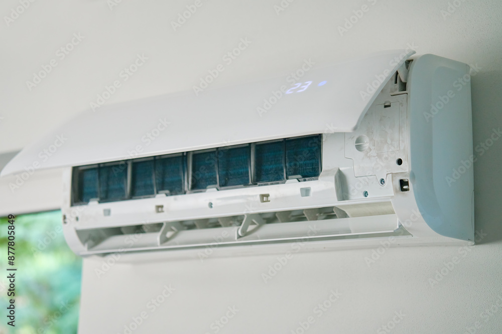White air conditioner unit is mounted on wall, ready for maintenance. Climate system with opened front cover revealing internal components. Repairing HVAC in apartment White air conditioner unit is mounted on wall, ready for maintenance. Climate system with opened front cover revealing internal components. Repairing HVAC in apartment