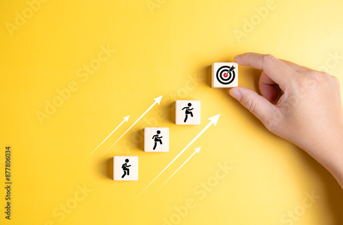 Life or business achievement and objective target for success. Rises upstairs to company target. Human icons climb on a stacked wooden block to the final goal. Human self-improvement and growth.