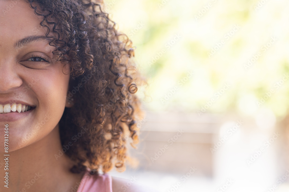 Smiling woman with curly hair enjoying outdoor time, close-up portrait, copy space Smiling woman with curly hair enjoying outdoor time, close-up portrait, copy space