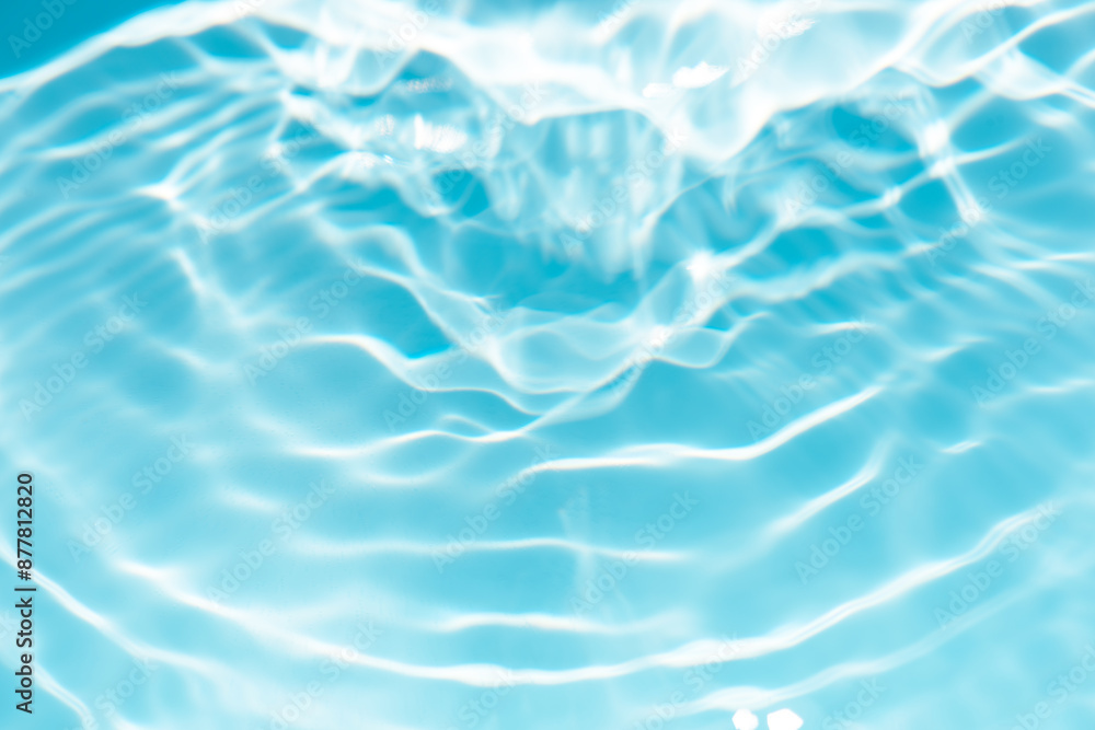 Fototapeta premium Blue water with ripples on the surface. Defocus blurred transparent blue colored clear calm water surface texture with splashes and bubbles. Water waves with shining pattern texture background.