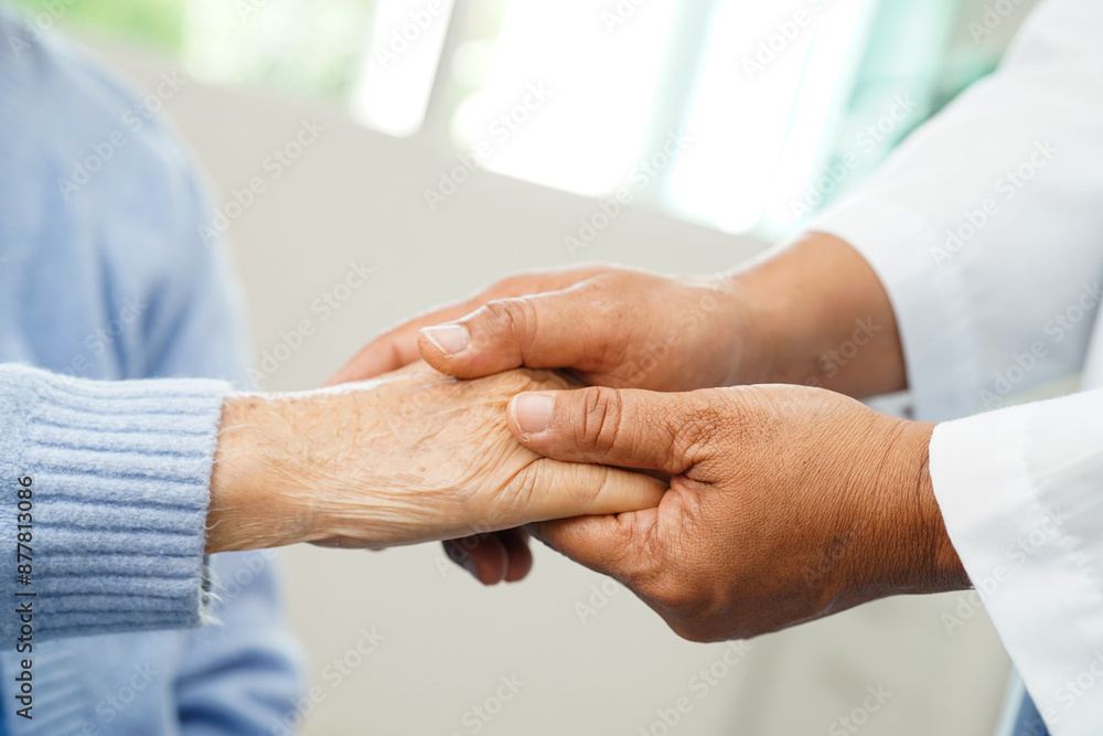 Doctor holding hand and help senior woman patient in hospital.