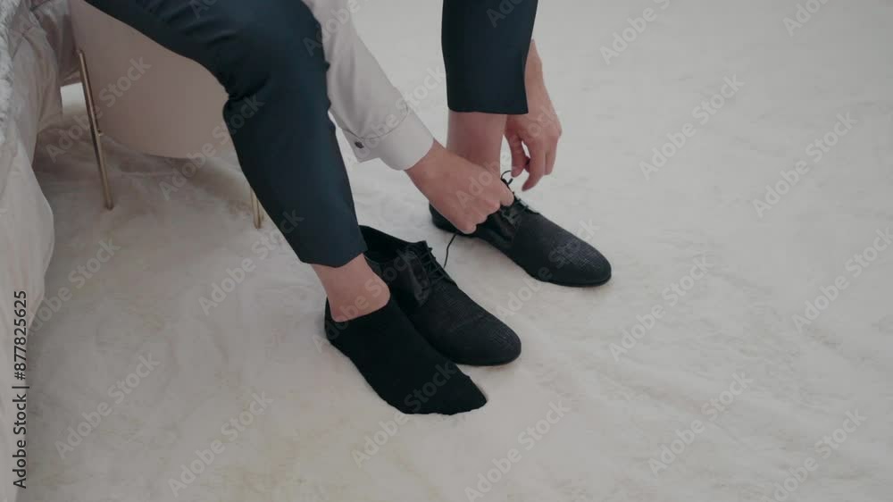 Man sitting down and tying his black dress shoes, preparing for an event. Man sitting down and tying his black dress shoes, preparing for an event.