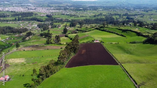 Aerial drone flight, green fields of Province of Pichincha, Ecuador, city of Machachi in the background, dolly shot