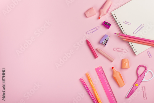 Back to school concept. pencils, sharpener, scissors, pens on pink background with copy space. Flat lay, top view.