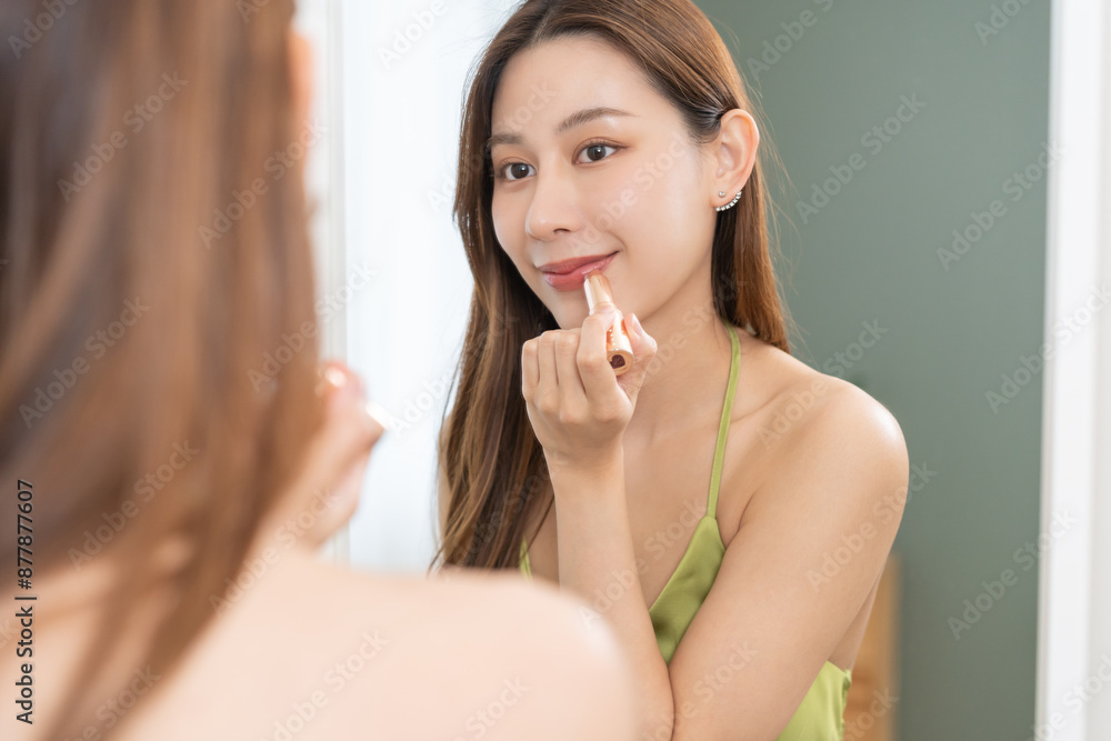Get dress, elegant asian young woman with makeup applying red lips glamour, getting ready wearing green cloth, gorgeous female looking into mirror at home, prepare going event night party, celebration Get dress, elegant asian young woman with makeup applying red lips glamour, getting ready wearing green cloth, gorgeous female looking into mirror at home, prepare going event night party, celebration