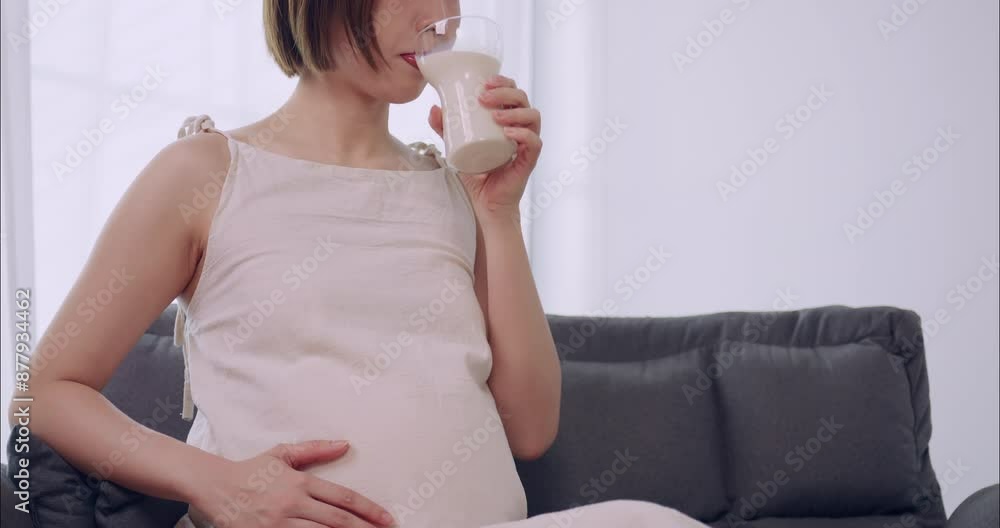Asian pregnant woman drinking milk for the health of herself and her unborn baby. Asian pregnant woman drinking milk for the health of herself and her unborn baby.