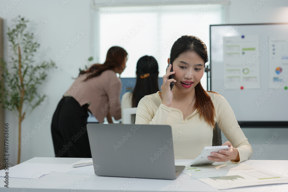 Young young woman with creative Asian business team, office colleagues using smartphone to contact business customers online Successful partnership in teamwork, startup business concept. Young young woman with creative Asian business team, office colleagues using smartphone to contact business customers online Successful partnership in teamwork, startup business concept.