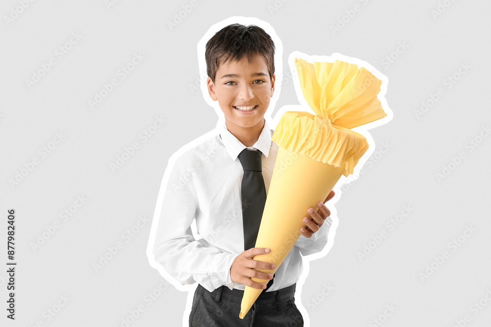 Little boy with yellow school cone on light background Little boy with yellow school cone on light background