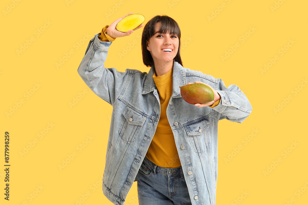 Beautiful young woman with ripe mangoes on yellow background Beautiful young woman with ripe mangoes on yellow background