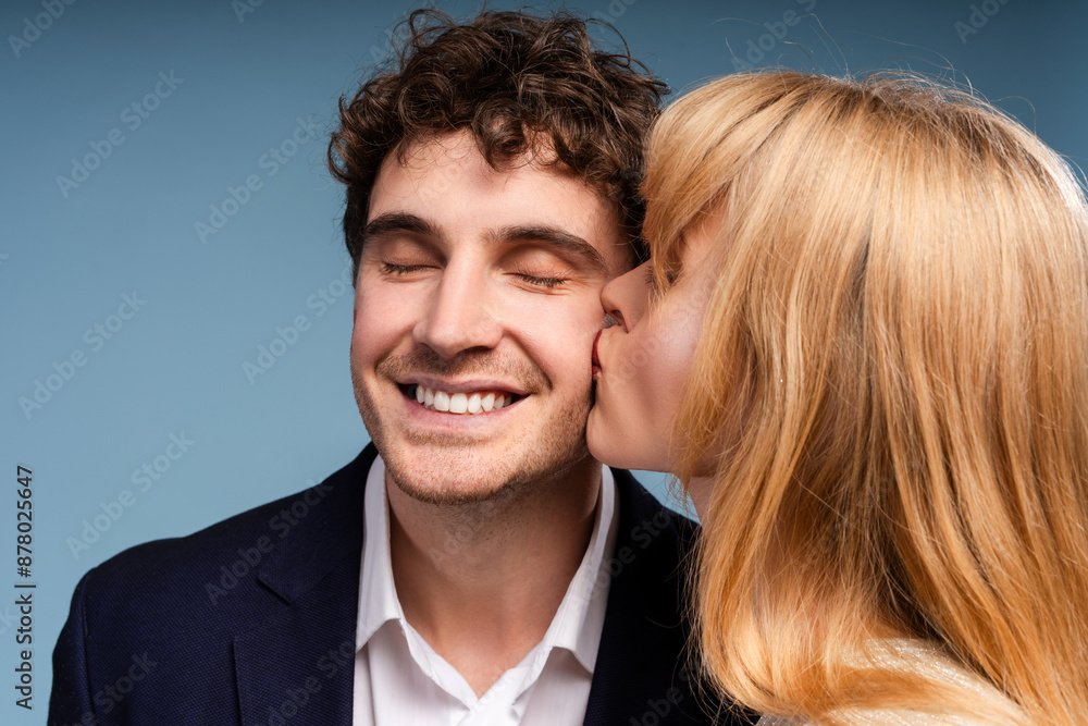 Man and woman kissing standing isolated on blue background Man and woman kissing standing isolated on blue background