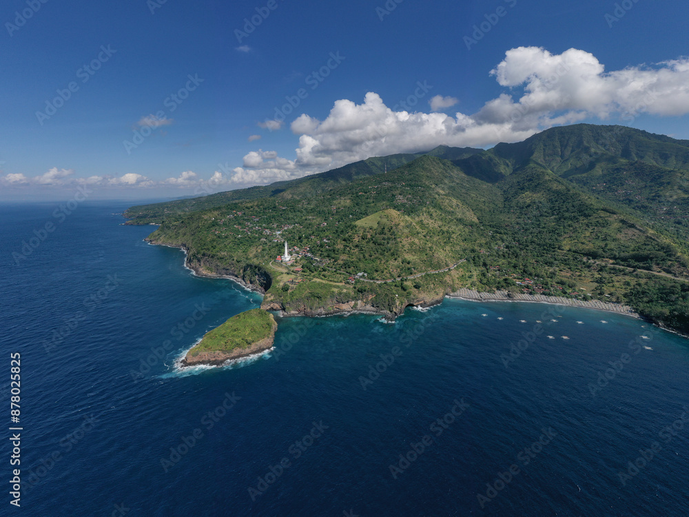 Obraz premium Majestic drone view of the coastline east Bali, where green hills merge with the deep blue sea.