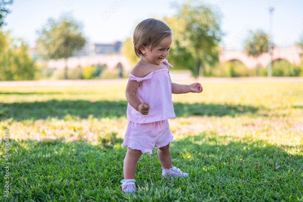 Baby Girl In A Pink Dress Playing Outdoors Baby Girl In A Pink Dress Playing Outdoors