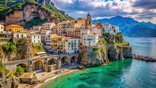 Vibrant Mediterranean houses tumble down a rugged cliff in Atrani, Amalfi Coast, overlooking turquoise waters and a serene beach surrounded by lush green hillsides.