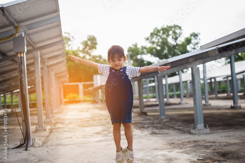 girl playing in field by solar panel photo