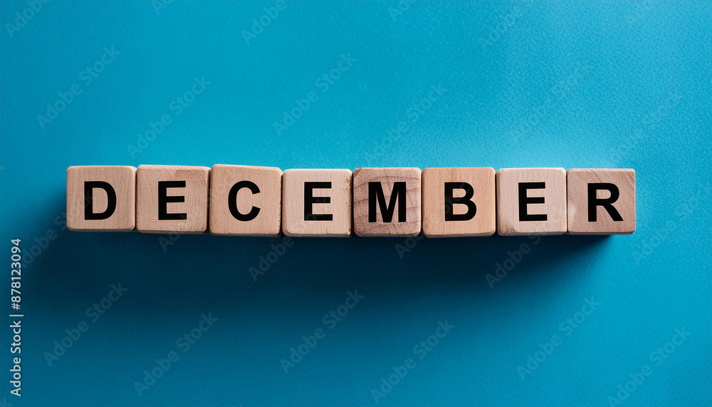 Wooden cubes with text DECEMBER on blue backdrop. Winter season. Month of year. Close-up. Flat lay Wooden cubes with text DECEMBER on blue backdrop. Winter season. Month of year. Close-up. Flat lay