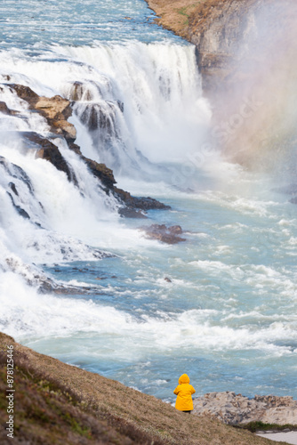 Obraz na płótnie Stunning view of the Gullfoss waterfall with a tourist wearing a yellow jacket. Gullfoss is the most popular waterfall in Iceland and one of its most iconic sights. w salonie
