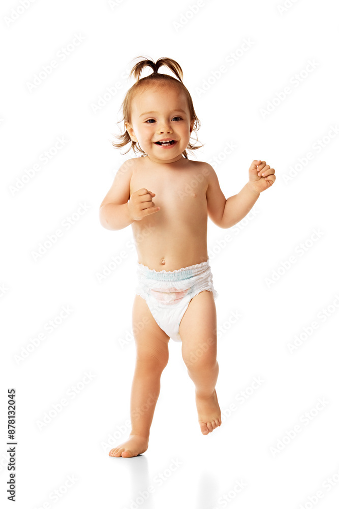 Happy, smiling baby girl in diaper walking with laugh and joy isolated on white background. Active and healthy. Concept of childhood, care, health, infancy, lifestyle, motherhood Happy, smiling baby girl in diaper walking with laugh and joy isolated on white background. Active and healthy. Concept of childhood, care, health, infancy, lifestyle, motherhood