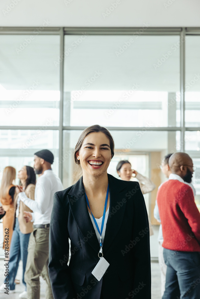 Obraz premium Cheerful woman at an office conference with colleagues in the background