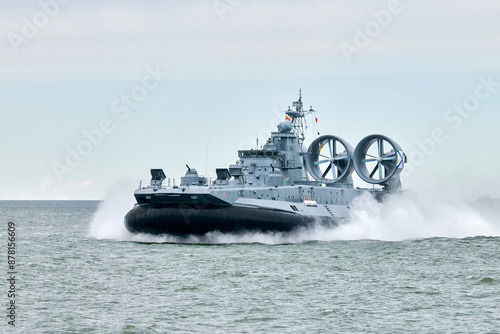 Hovercraft warship armed with armament sails into sea toward military target to attack and destroy enemy, military hovercraft ship performing strategic maneuver, Russian sea power deployment photo