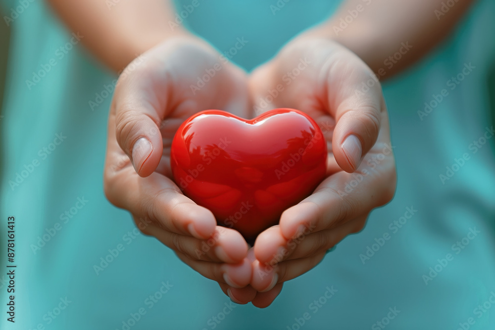 Fototapeta premium Red heart in hands, close-up. Concept of love, care, health, medicine