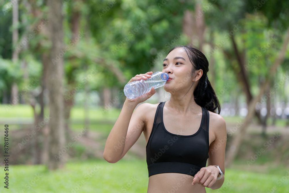 Young Woman Drinking Water After Exercise in a Park on a Sunny Day Young Woman Drinking Water After Exercise in a Park on a Sunny Day