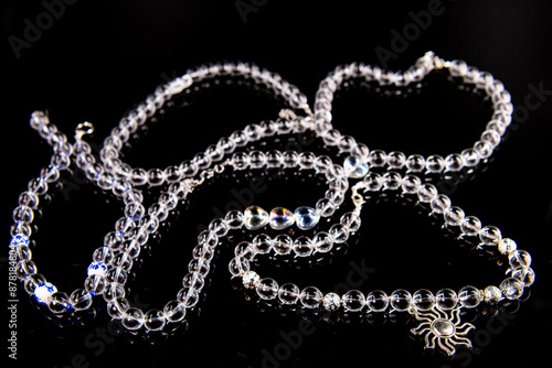 Five glass necklaces with big beads on a black background laying flat on the table, ethnic jewelry