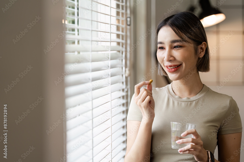 Young Woman Taking Pills with Water by Window - Healthcare and Medication Concept Young Woman Taking Pills with Water by Window - Healthcare and Medication Concept
