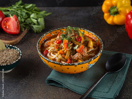 Delicious lagman soup, uzbek lagman soup, Asian cuisine, lagman soup with meat and vegetables. Lagman soup with beef, noodles, sweet peppers, onions and herbs. photo