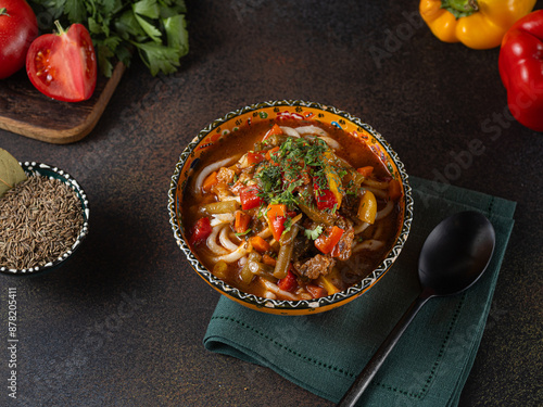 Delicious lagman soup, uzbek lagman soup, Asian cuisine, lagman soup with meat and vegetables. Lagman soup with beef, noodles, sweet peppers, onions and herbs. photo