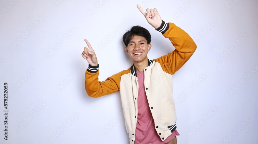 casual smiling young handsome asian man giving a gesture pointing upwards casual smiling young handsome asian man giving a gesture pointing upwards