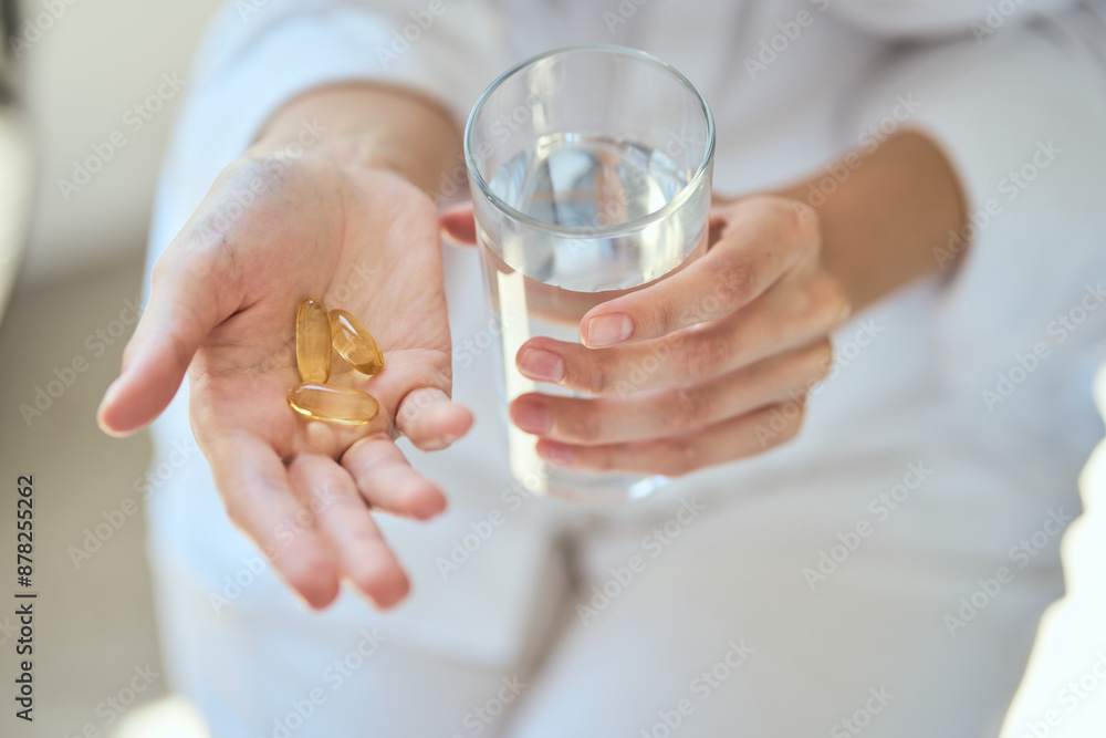 Hands Holding Omega-3 And Glass Of Water, Emphasizing Health, Wellness, And Daily Routine Habits. The Image Portrays A Serene And Wholesome Lifestyle Concept. Hands Holding Omega-3 And Glass Of Water, Emphasizing Health, Wellness, And Daily Routine Habits. The Image Portrays A Serene And Wholesome Lifestyle Concept.