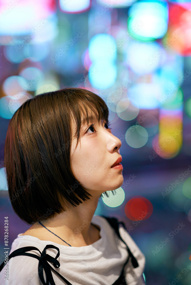 夜に光輝く繁華街と若い女性 夜に光輝く繁華街と若い女性
