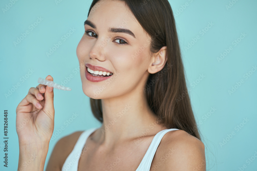 Dental Care. Woman Holding Dental Aligners, Smiling With Perfect Teeth On Blue Background. Concept Of Oral Health, Cosmetic Dentistry, And Self-Confidence. Dental Care. Woman Holding Dental Aligners, Smiling With Perfect Teeth On Blue Background. Concept Of Oral Health, Cosmetic Dentistry, And Self-Confidence.