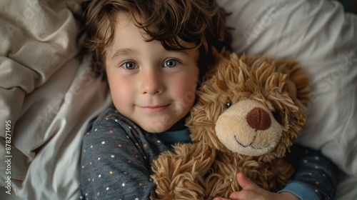 A cute child in pajamas, hugging a stuffed animal and getting ready for bedtime stories photo