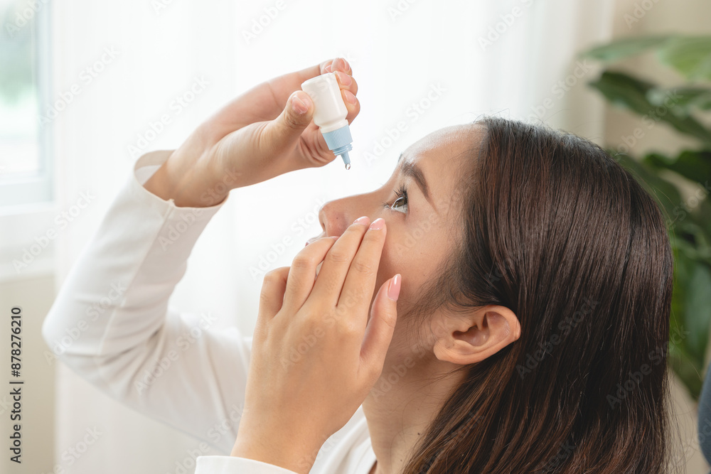 asian young woman using medical eye drops to treat dry eye and irritation. asian young woman using medical eye drops to treat dry eye and irritation.