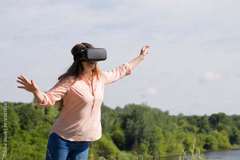 A young woman with virtual reality glasses imagines that she is flying A young woman with virtual reality glasses imagines that she is flying