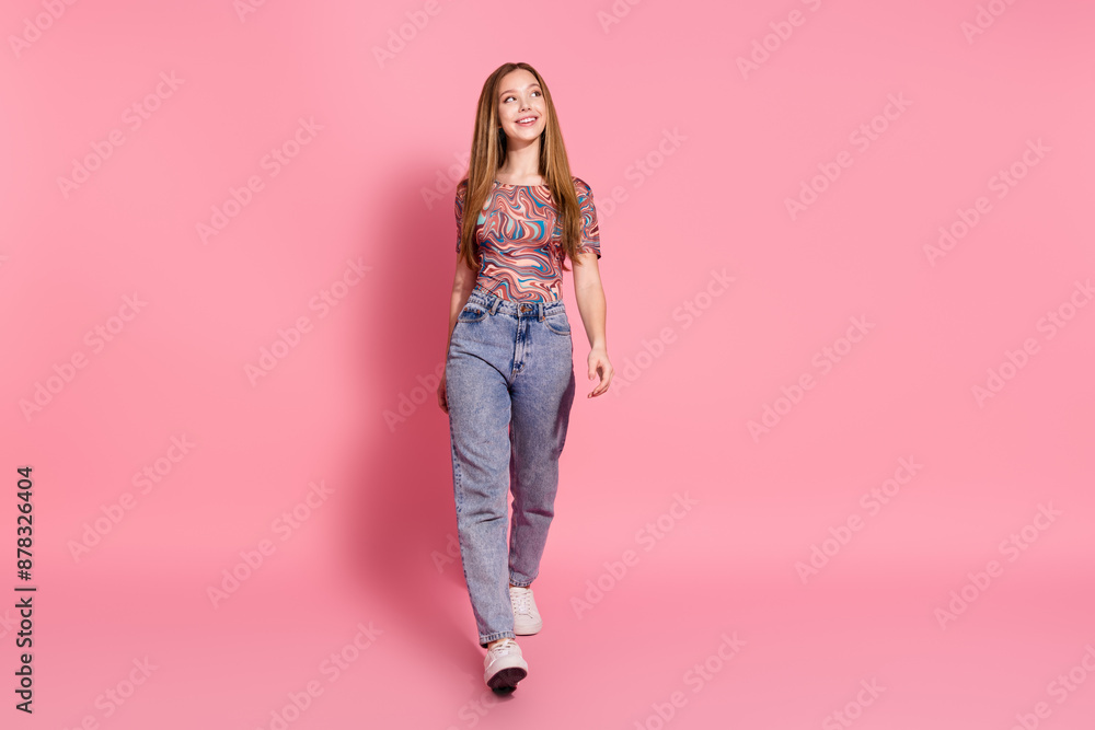 Full length photo of adorable dreamy girl wear print t-shirt denim trousers look at promo empty space isolated on pink color background Full length photo of adorable dreamy girl wear print t-shirt denim trousers look at promo empty space isolated on pink color background