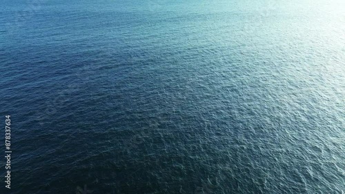 Aerial view of a school of dolphins frolicking in the ocean and splashing in the water. Distant view of dolphins swimming by underwater. Background video of marine mammals.