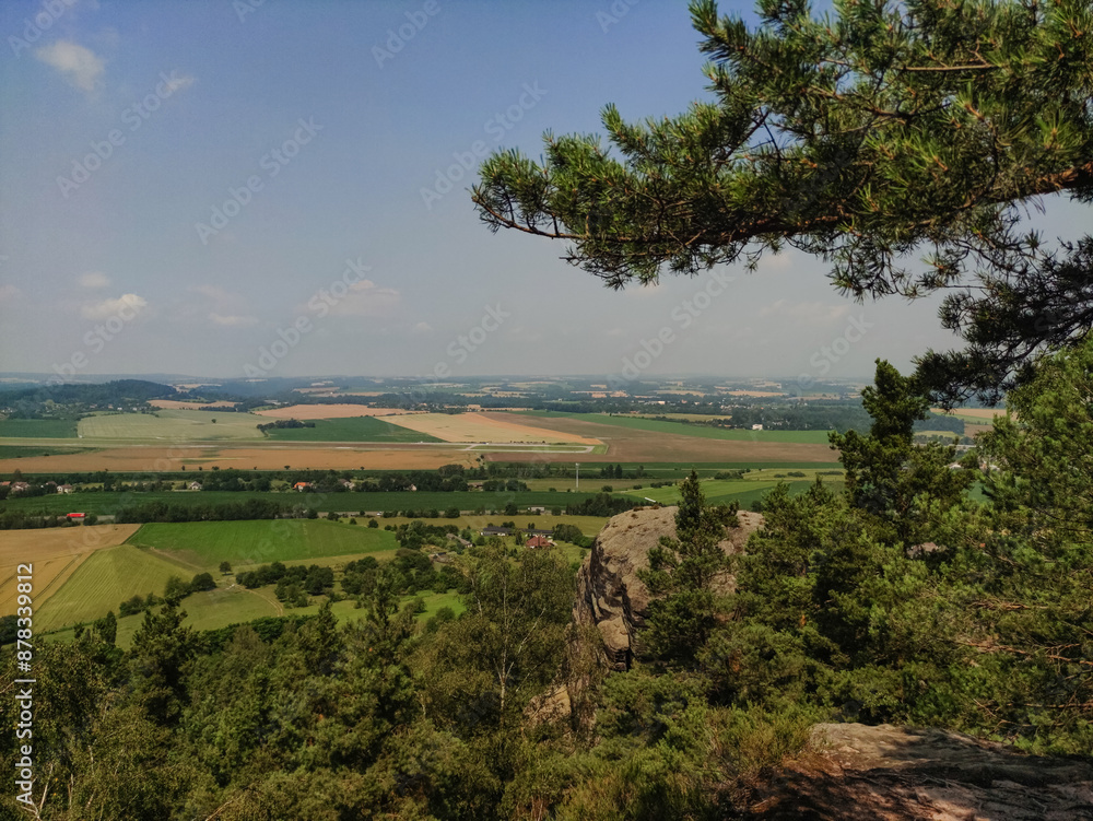 A picturesque view of a lush green valley with rolling hills and a distant town A picturesque view of a lush green valley with rolling hills and a distant town