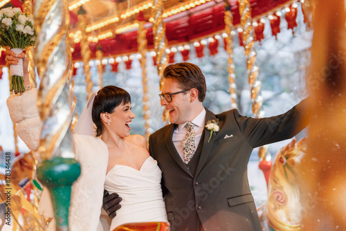 Bride and Groom Laughing on Carousel During Winter Wedding