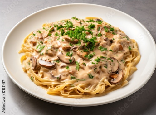  A plate of cooked pasta with mushrooms and parsley on a rustic wooden table.