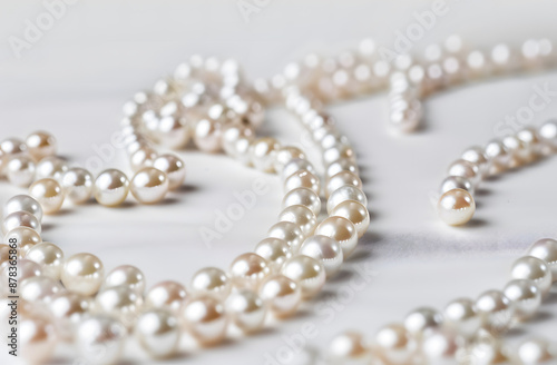 Elegant pearl necklace with lustrous pearls isolated on a white background.