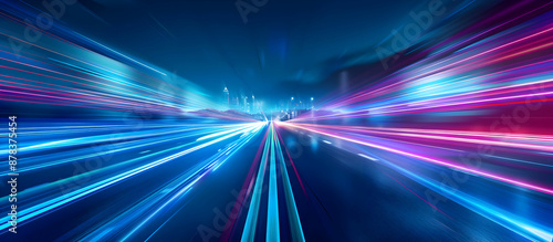 Dynamic light trails on a city street at night, capturing motion and speed with vibrant blue and pink streaks.